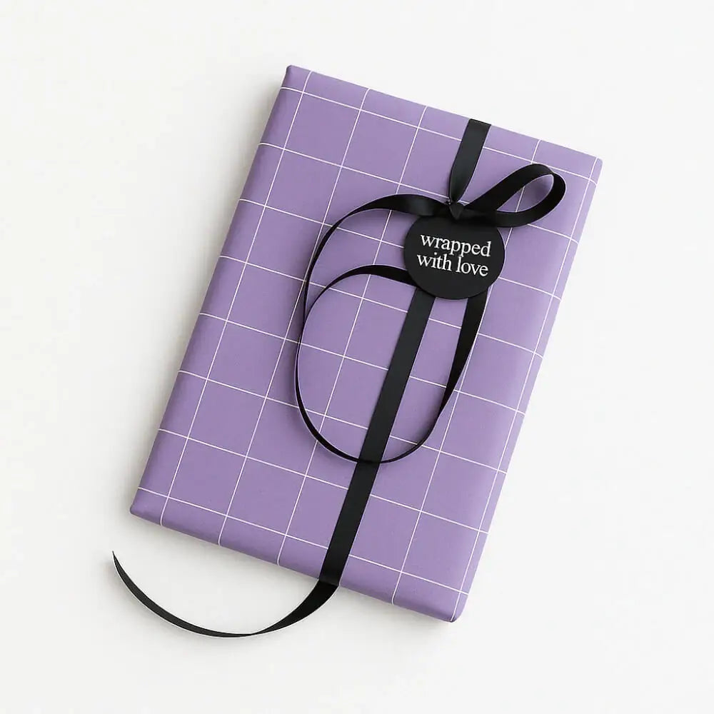 Paarse cadeauverpakking met zwart lint en tag "wrapped with love".