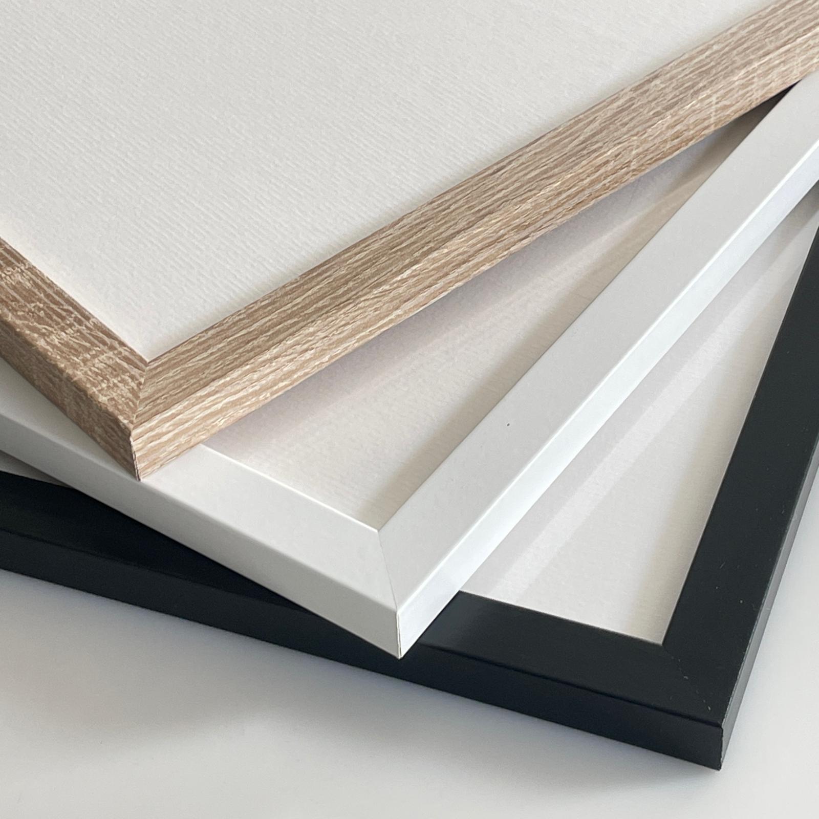 Houten, witte en zwarte fotolijsten gestapeld op een witte achtergrond.