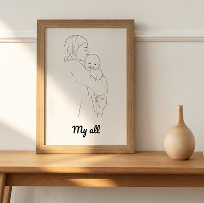 Portrettekening van een moeder met baby in houten lijst op houten tafel.