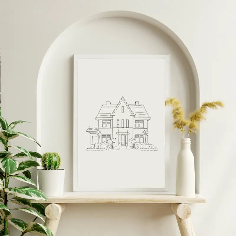 Tekening van een huis in een lijst op een houten plank met planten.