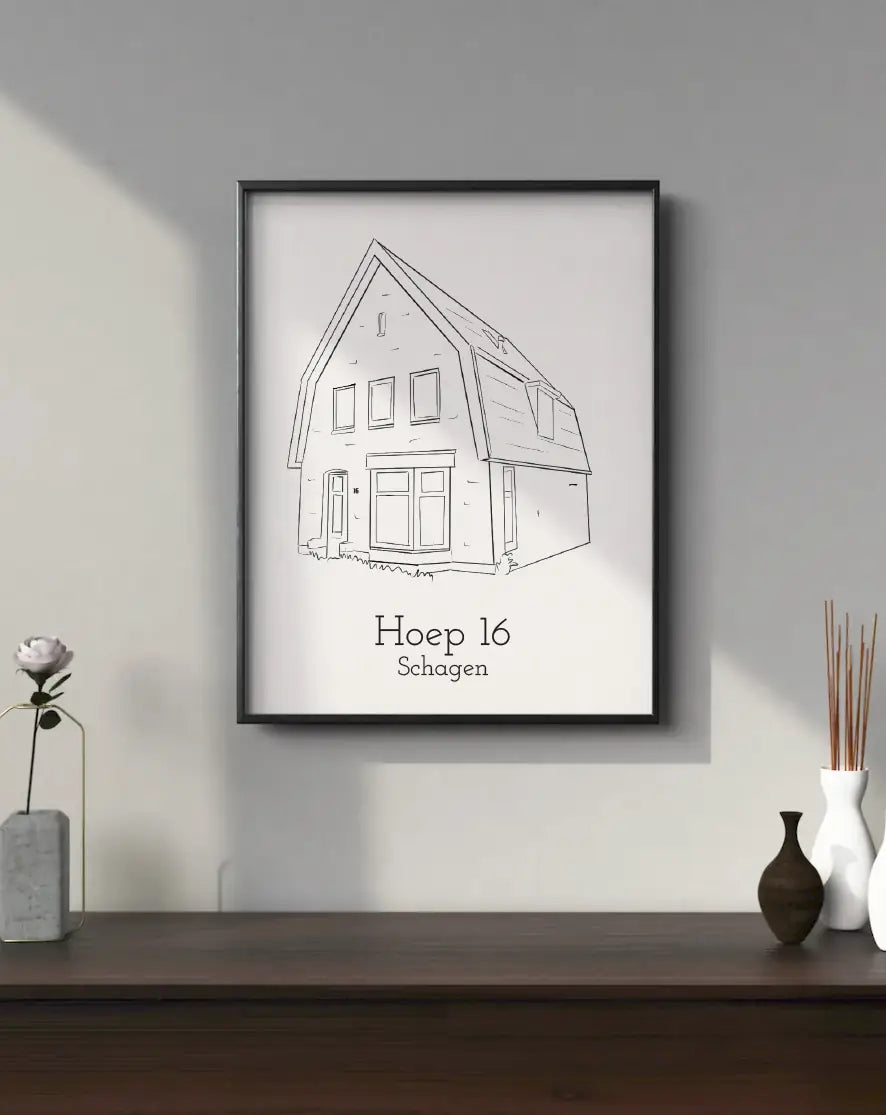 Potloodtekening van huis Hoep 16 in Schagen in zwarte lijst op tafel met decoratie.