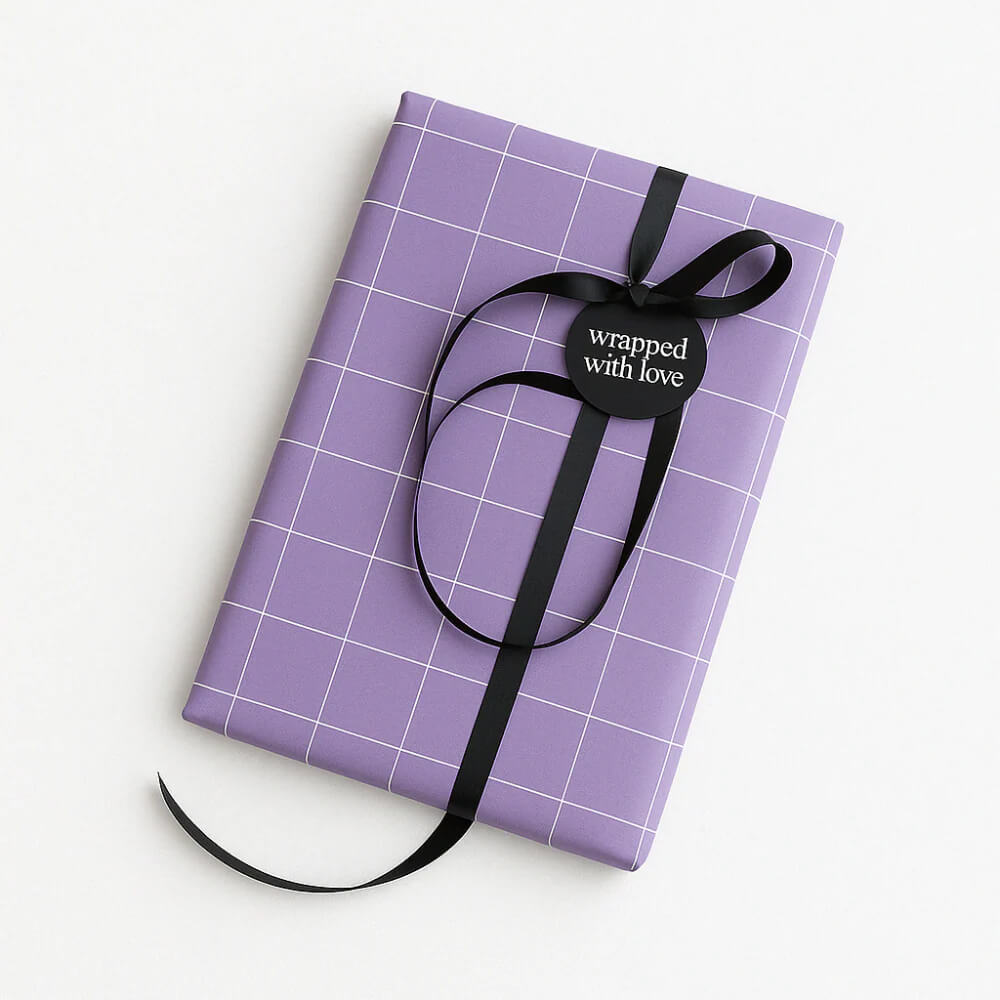Paarse cadeaudoos met rasterprint en zwarte strik, etiket "wrapped with love".